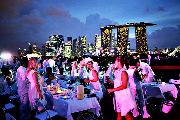 Guests gather at dinner tables set up with the Marina Bay Sands